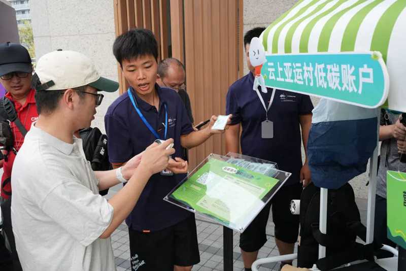 9月12日，工作人員指導(dǎo)媒體記者開啟云上亞運村低碳賬戶。新華社記者翁忻旸攝.jpg