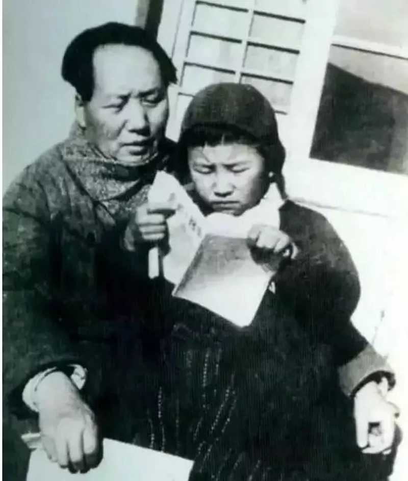 1946年毛澤東在延安窯洞前教女兒李訥識(shí)字。.jpg
